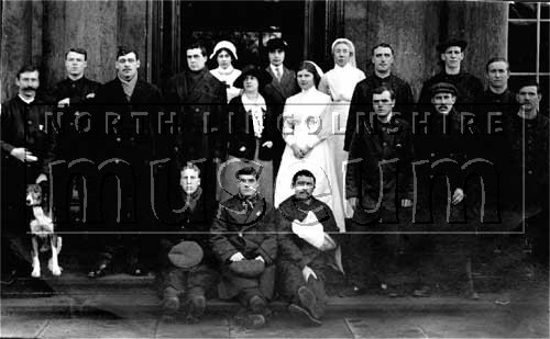 Convalescing soldiers on the steps of the main entrance to Normanby Hall, c.1914-1918. 	