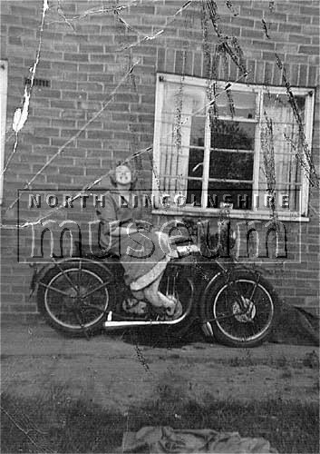 Member of the Smith family of 23 Friars Road, Scunthorpe, posing on a motorbike. Taken in their back garden on the Manor Farm Estate, c.1960's 	