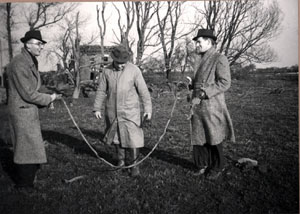 Men using a parachute mine as a skipping rope at Goxhill Marsh after an air raid during the Second World War on 13 March 1941 	