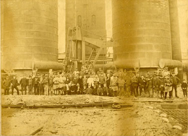Men and children gathered at Trent Iron Works in front of the towers.