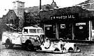Dodge towing ambulance and 2 model cars outside C.W. Marshall's garage, High St East. 