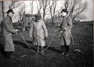 Men using a parachute mine as a skipping rope at Goxhill Marsh after an air raid during the Second World War on 13 March 1941 	